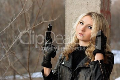 Confused blonde girl with a gun