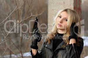 Confused blonde girl with a gun