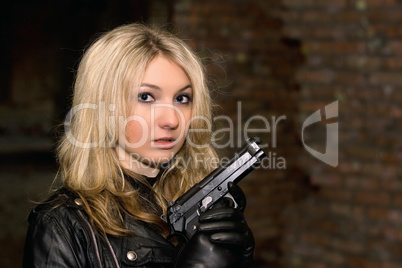 Scared beautiful woman with a gun