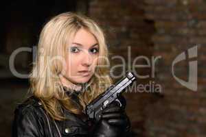 Scared beautiful woman with a gun