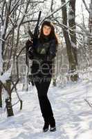 woman with a rifle in winter forest