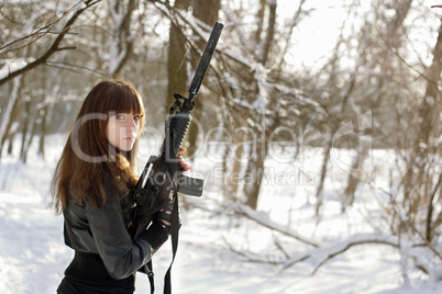 Armed woman in the winter forest