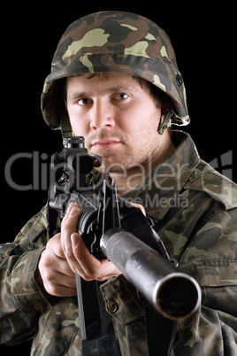 Soldier holding a gun in studio