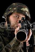 Ready soldier aiming a rifle in studio