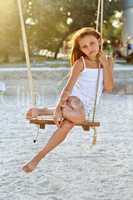 little girl sitting on a swing