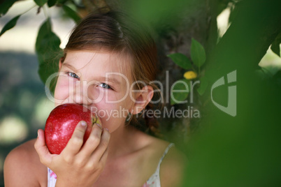 Kleines Mädchen beisst in einen Apfel