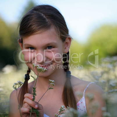 Mädchen riecht an einer Blume