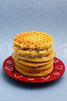 Red plate with six blueberry waffles