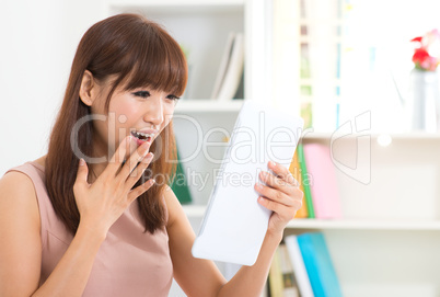 Surprise Asian female with tablet