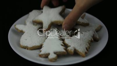 Hands taking Christmas cookie