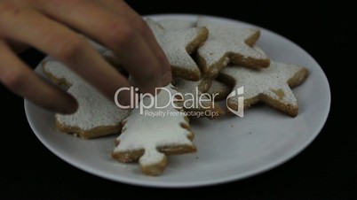 Young hands taking Christmas cookies