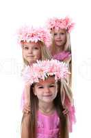Three beautiful little girls with pink wreaths