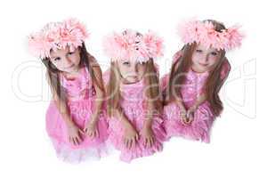 Three beautiful little girls with pink wreaths