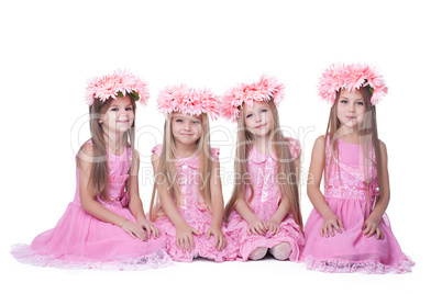 Four little girls with long hair in pink dresses