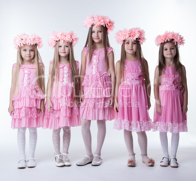 Little girls in glamour pink dresses and wreaths