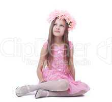 Little girl in pink dress and wreath sitting