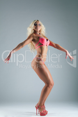 Athletic blond woman posing in rose bikini