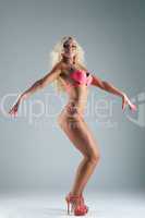 Athletic blond woman posing in rose bikini