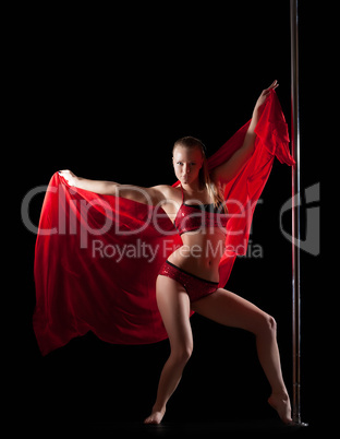 Woman posing in pole dance with red silk fabric