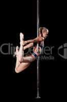 Blond woman during pole dance show exercise