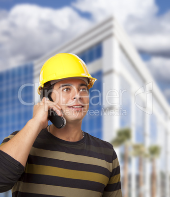 Hispanic Male Contractor on Phone in Front of Building