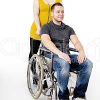 Man in wheelchair being pushed by woman
