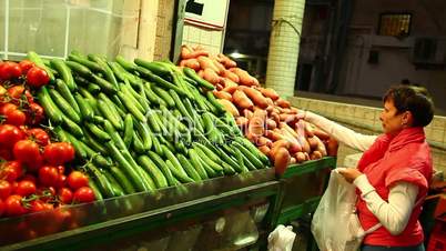 Woman chooses vegetables at the market.