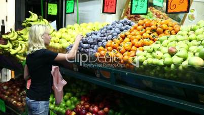 Girl chooses vegetables at the market.