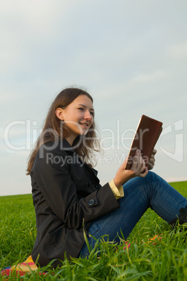 Teen girl reading the Bible outdoors