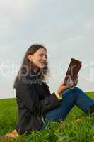 Teen girl reading the Bible outdoors