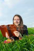 Teen girl reading the Bible outdoors