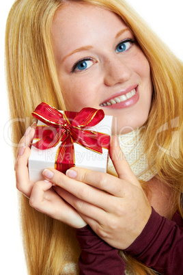 beautiful blonde woman holding a christmas gift is smiling