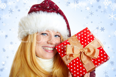 beautiful blonde woman holding a christmas gift is smiling