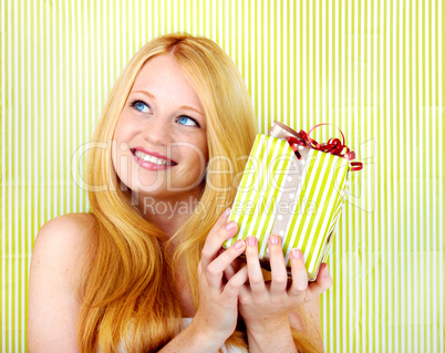 beautiful blonde woman holding a christmas gift is smiling