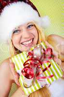 beautiful blonde woman holding a christmas gift is smiling