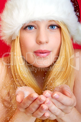 beautiful blonde woman blowing snow