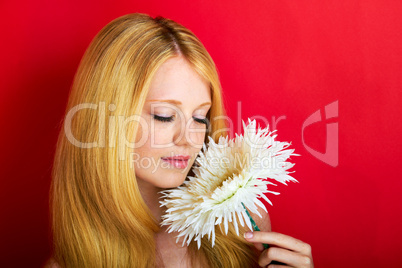 portrait of a young beautiful blonde girl with white flower