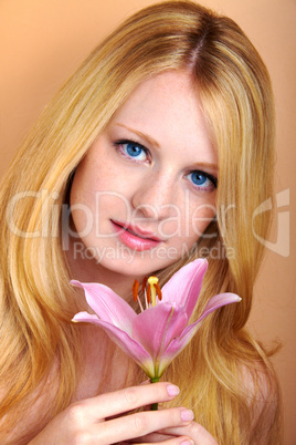 portrait of a young beautiful blonde girl with white flower