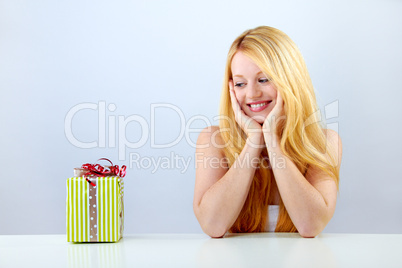 beautiful blonde woman holding a christmas gift is smiling