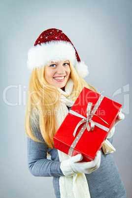 beautiful blonde woman holding a christmas gift is smiling