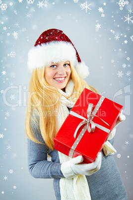 beautiful blonde woman holding a christmas gift is smiling