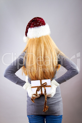 beautiful blonde woman holding a christmas gift is smiling