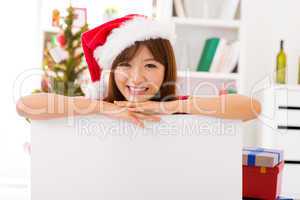 Christmas woman leaning over billboard sign