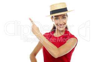 Smiling woman wearing straw bowler hat pointing away