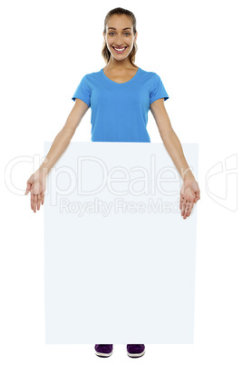 Joyous lady standing behind blank banner ad