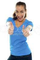 Overjoyed woman showing double thumbs up