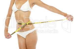 Fit woman measuring her waist, cropped image