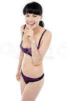 Gorgeous bikini model gesturing silence with a smile