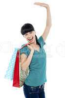 Excited shopaholic woman carrying bags