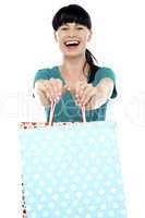Cheerful woman holding polka dot shopping bags